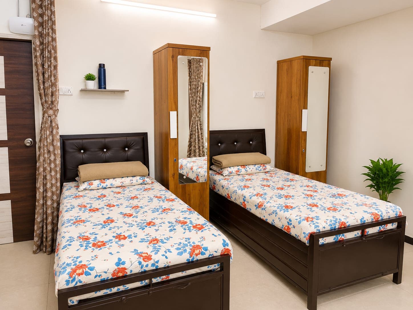 Girls' room with two beds, wooden wardrobes with mirrors and an attached balcony door