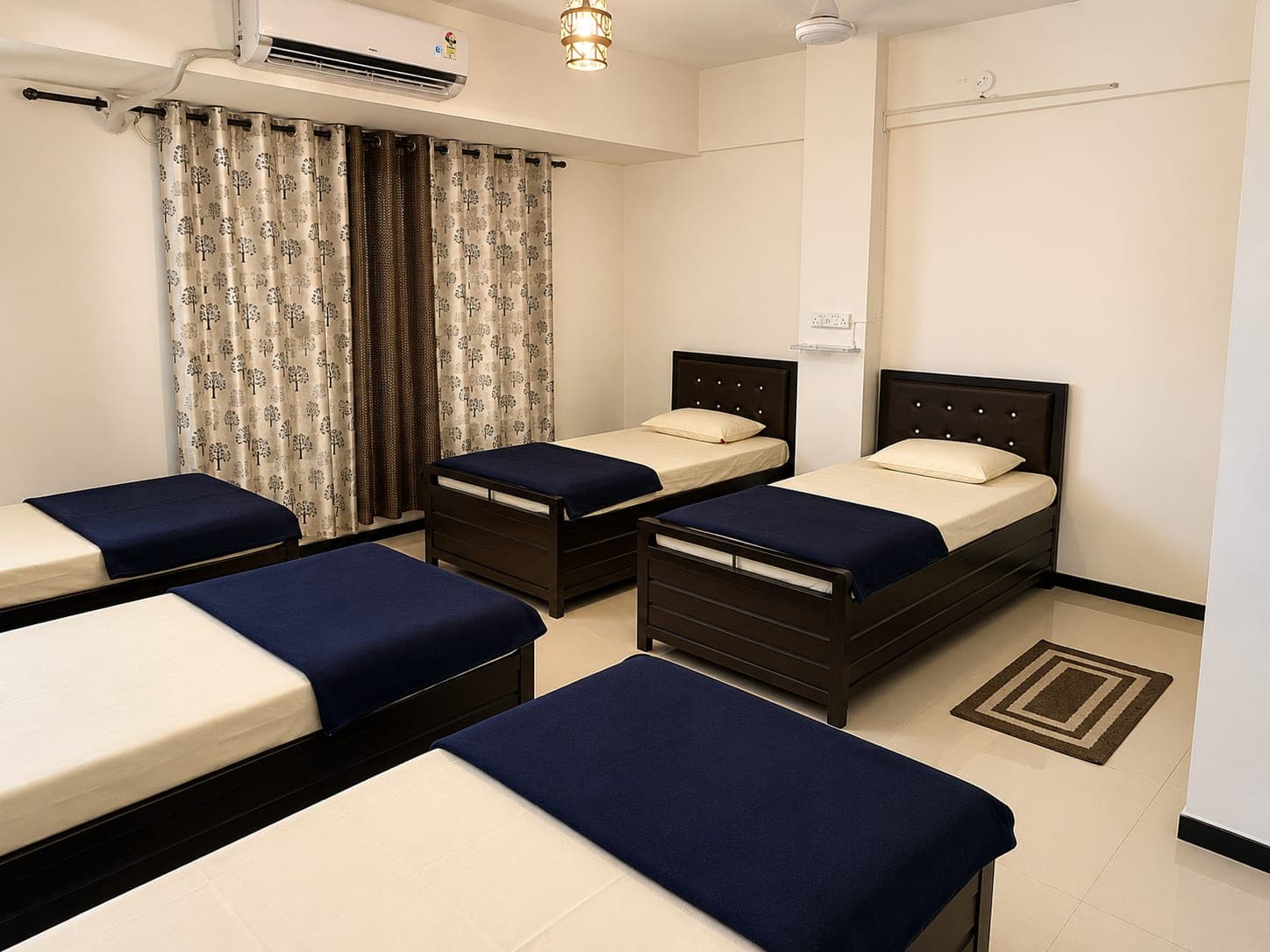 Four-sharing girls' room with four single beds, an air conditioner and blackout curtains